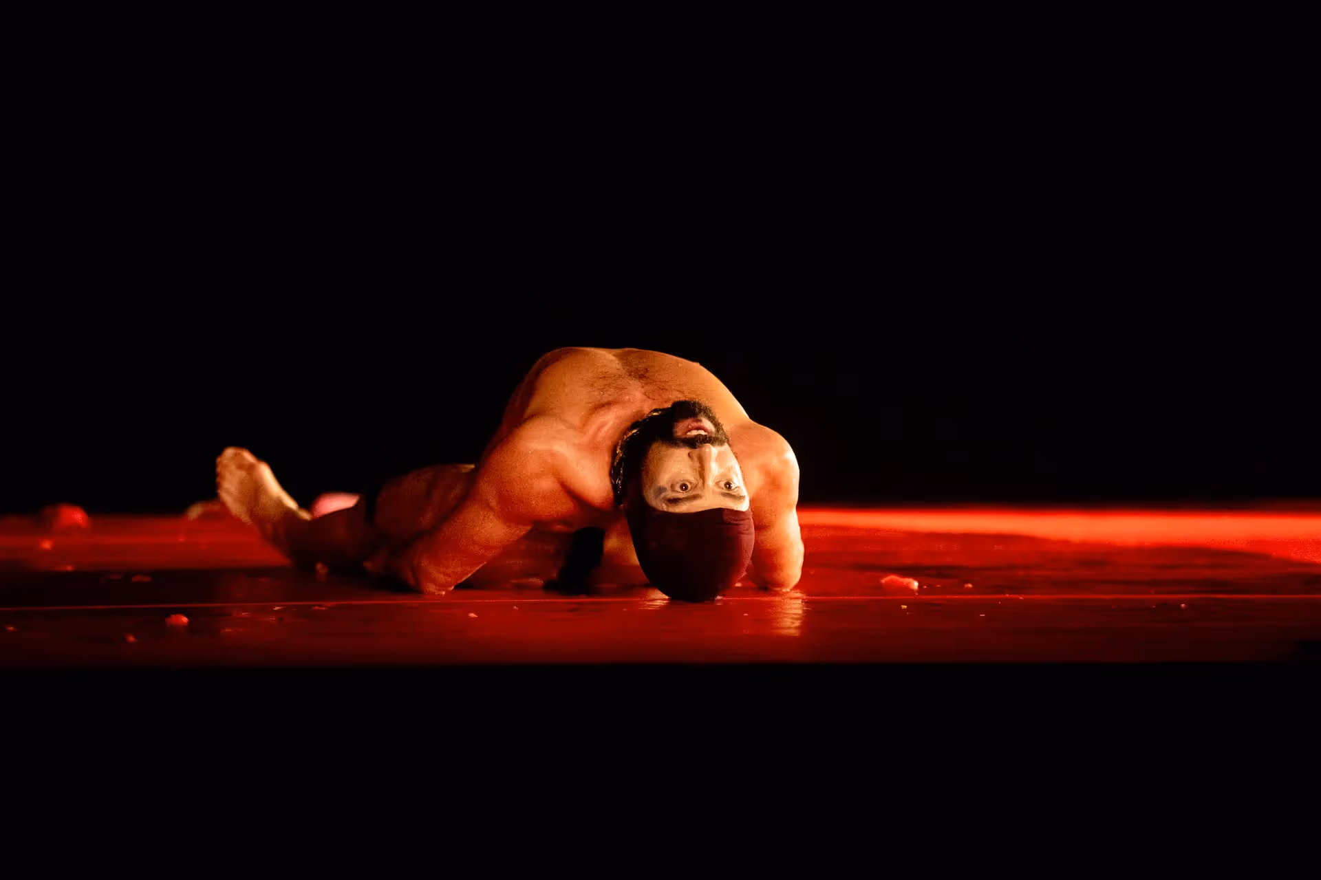 Dramatic performer at Festival di Spoleto with intense red stage lighting