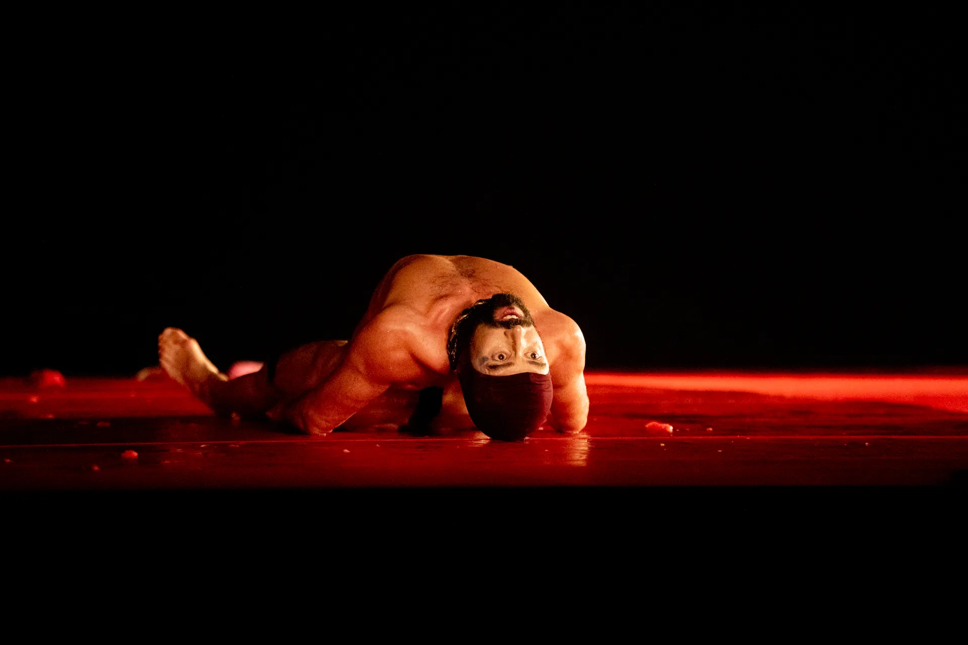 Performance artistica intensa al Festival di Spoleto con danzatore su sfondo rosso