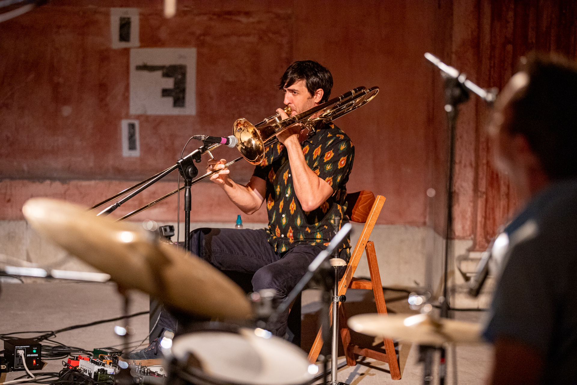 Trombonist performing at Festival di Spoleto, seated with microphones and instruments