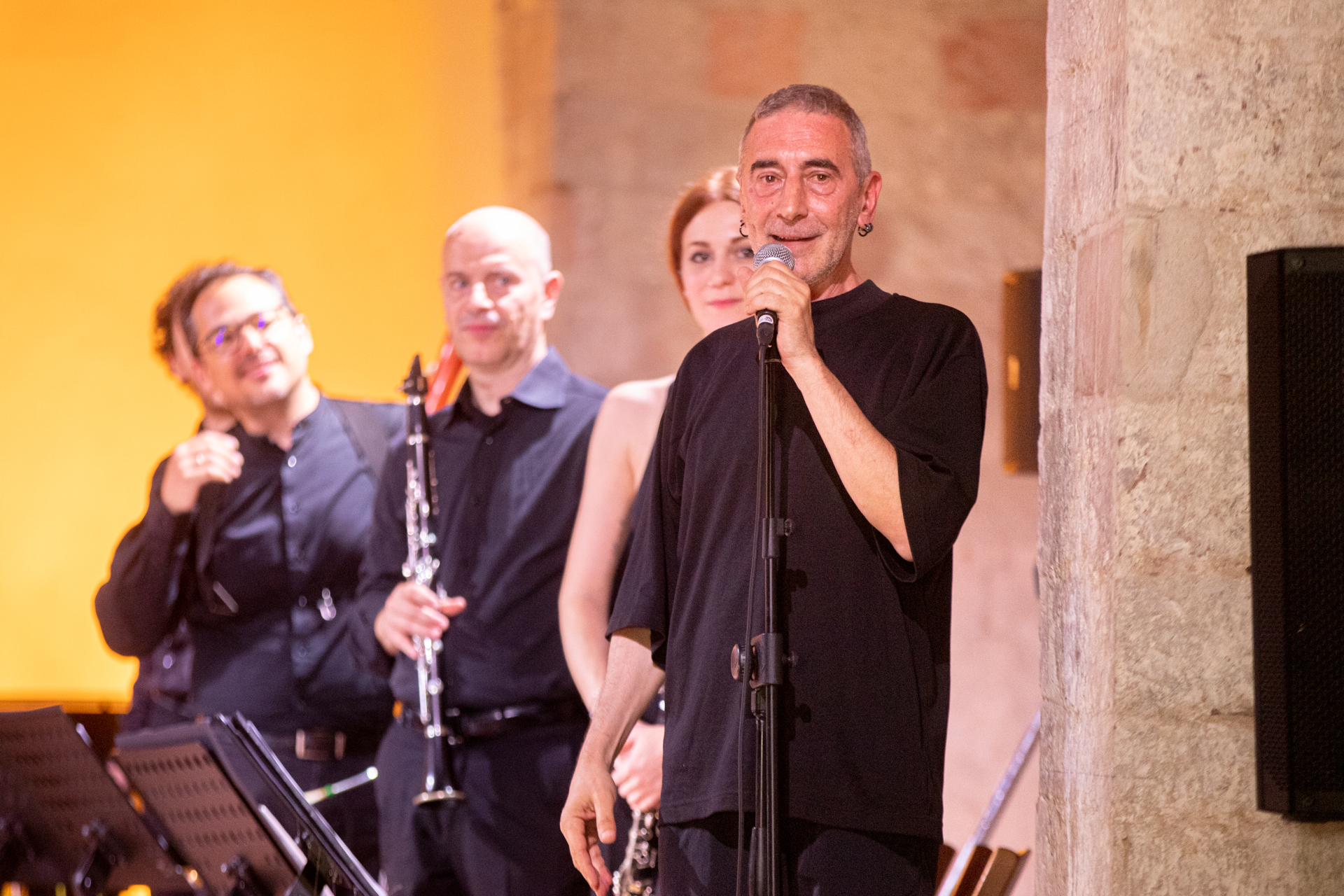 Musicians performing at Festival di Spoleto, black-clad ensemble with microphone