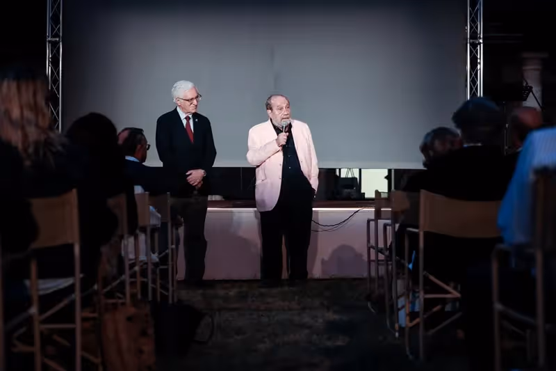 Speakers on stage during Festival di Spoleto event with audience in background