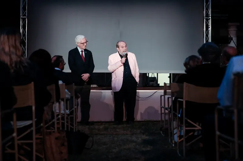 Speakers on stage during Festival di Spoleto event with audience in background