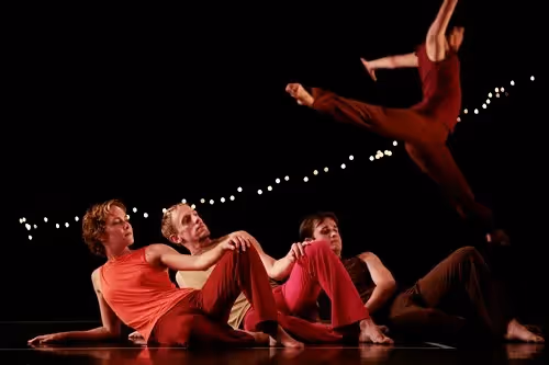Danzatori in movimento sul palco al Festival di Spoleto, luci soffuse
