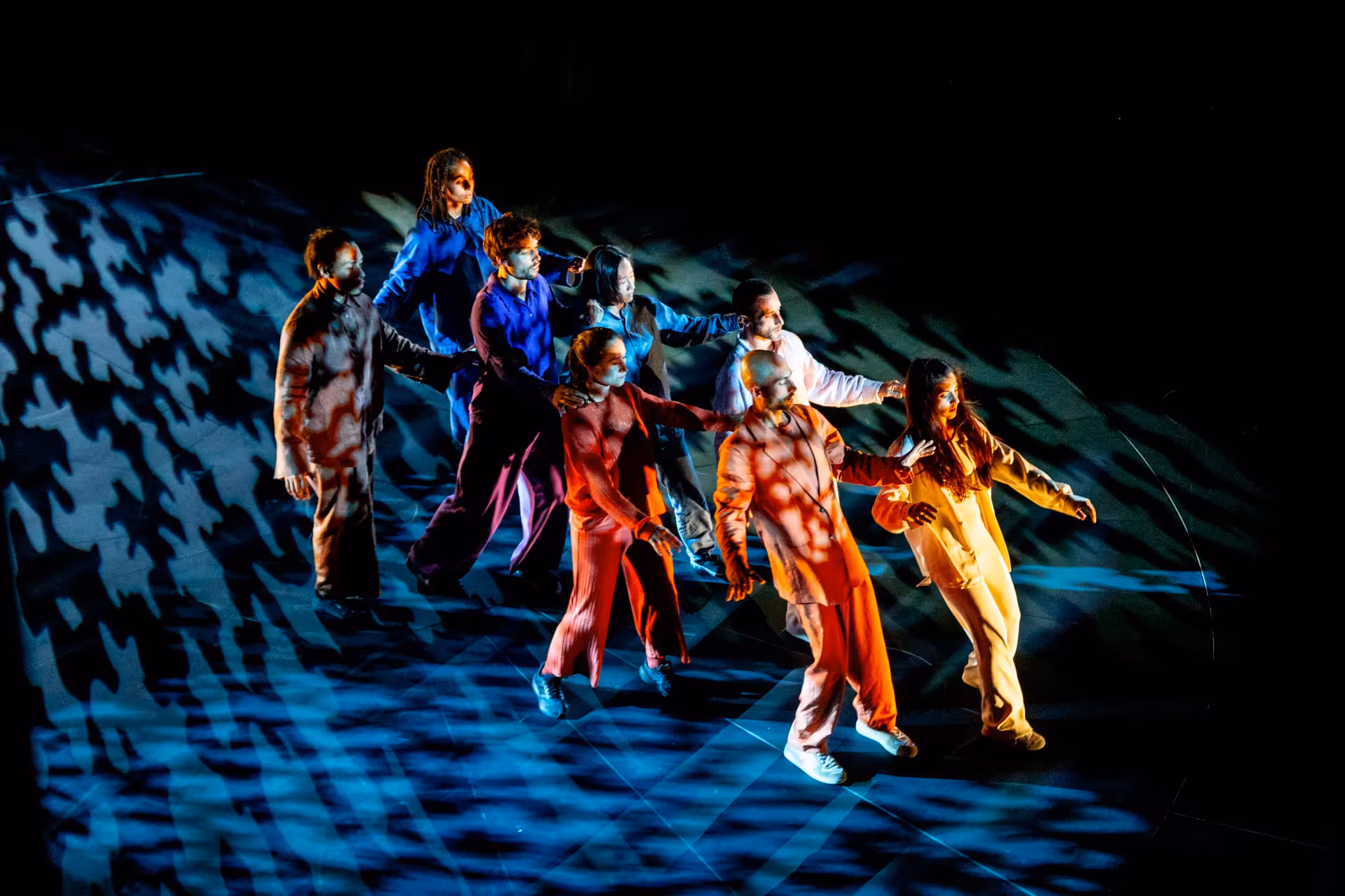Festival di Spoleto performers dancing in vibrant costumes under dramatic lighting