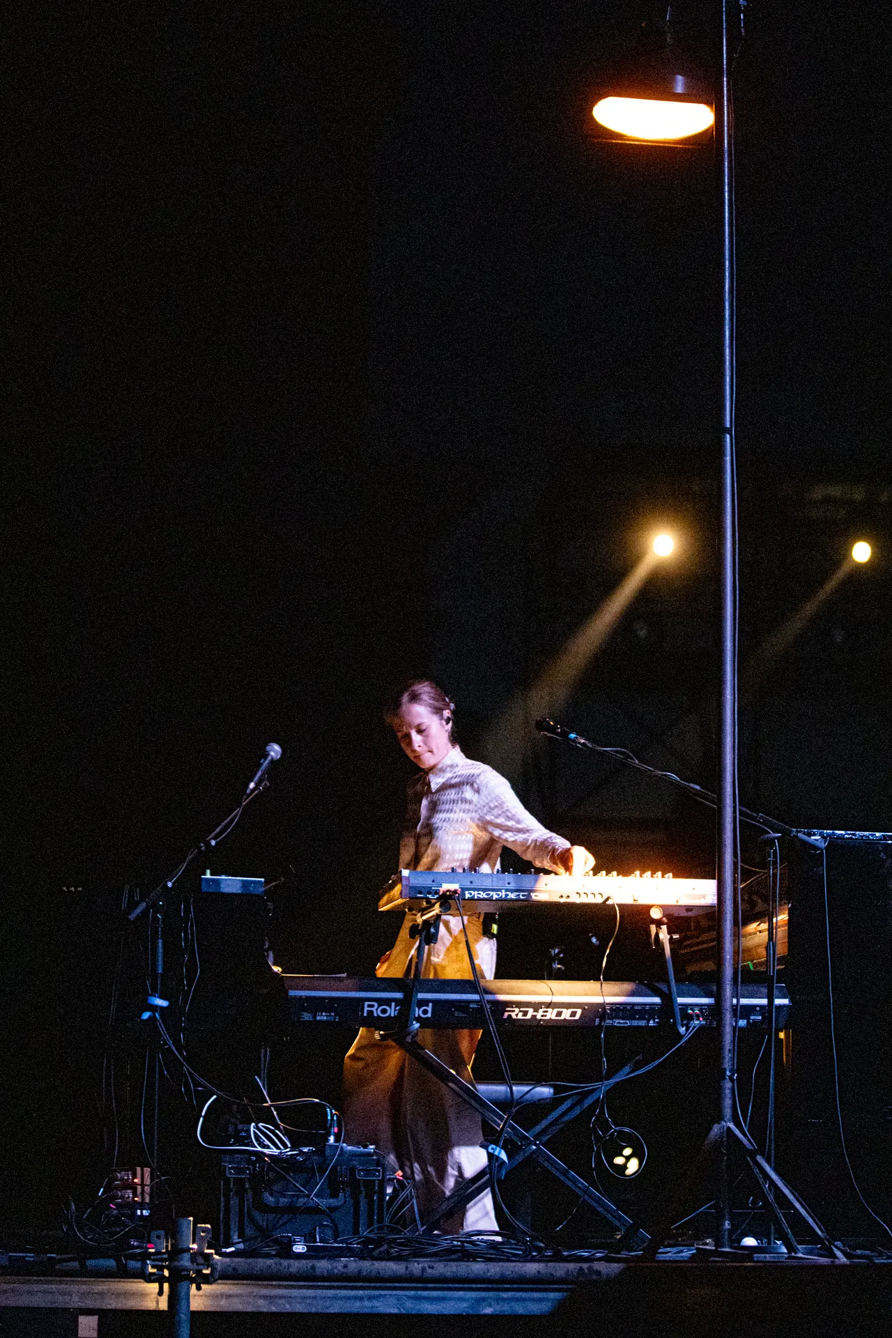 Electronic musician performing at Festival di Spoleto under dramatic stage lighting