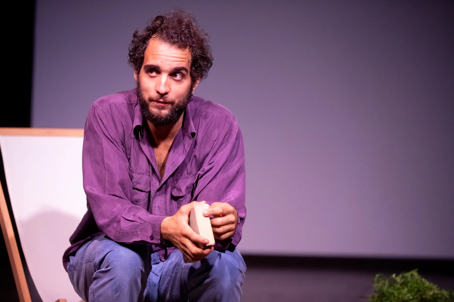 Attore sul palco durante il Festival di Spoleto, seduto in viola