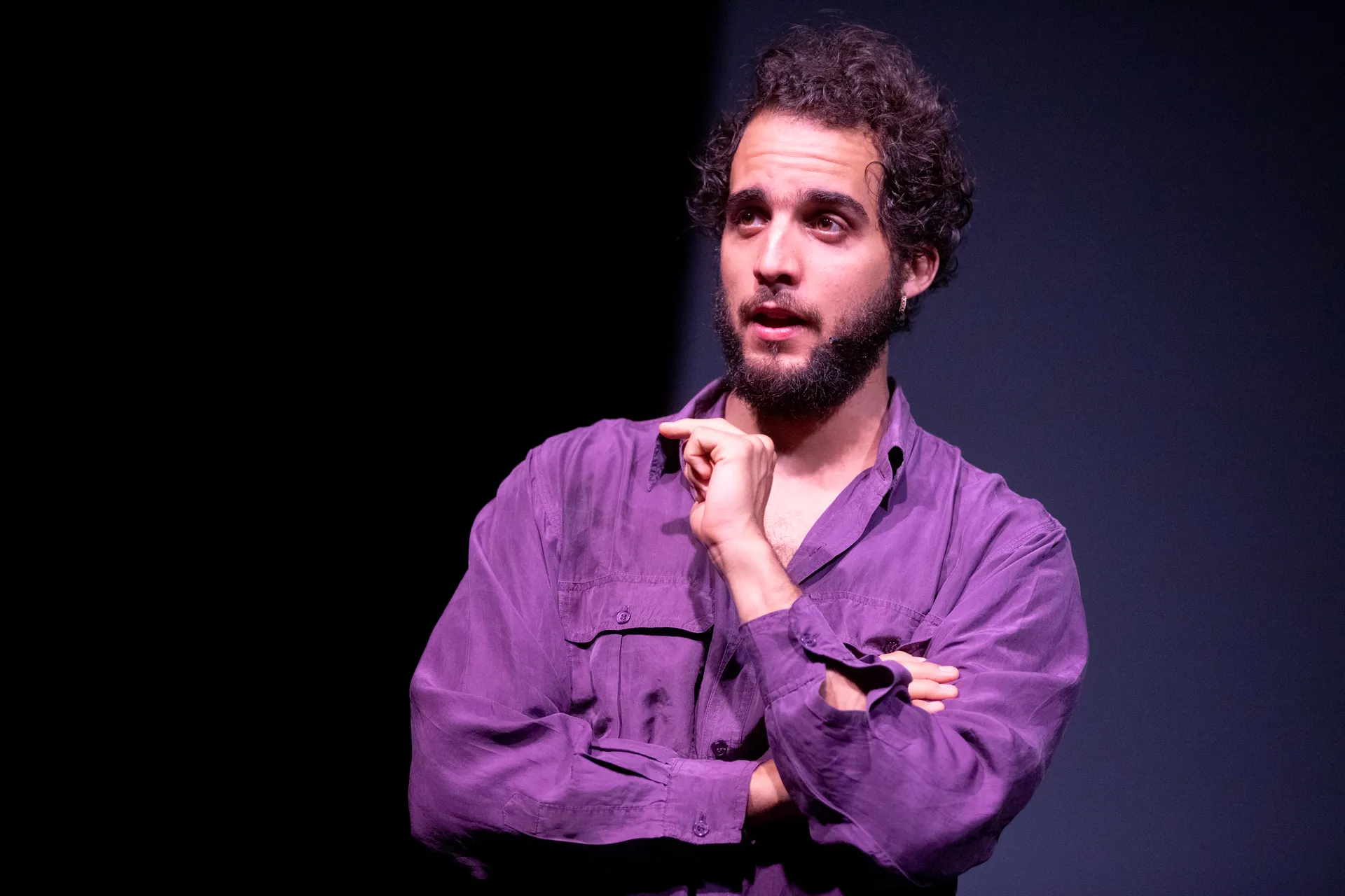 Attore in viola sul palco al Festival di Spoleto, espressivo e pensieroso