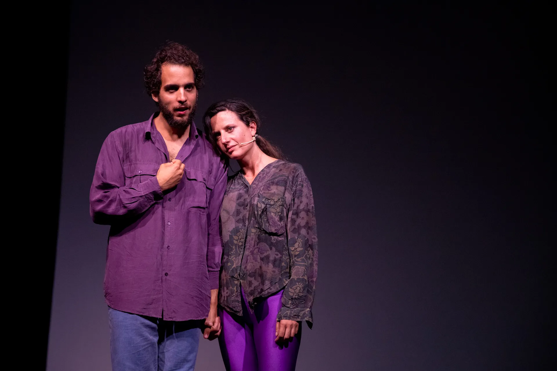 Attori sul palco durante il Festival di Spoleto, illuminati da luce viola