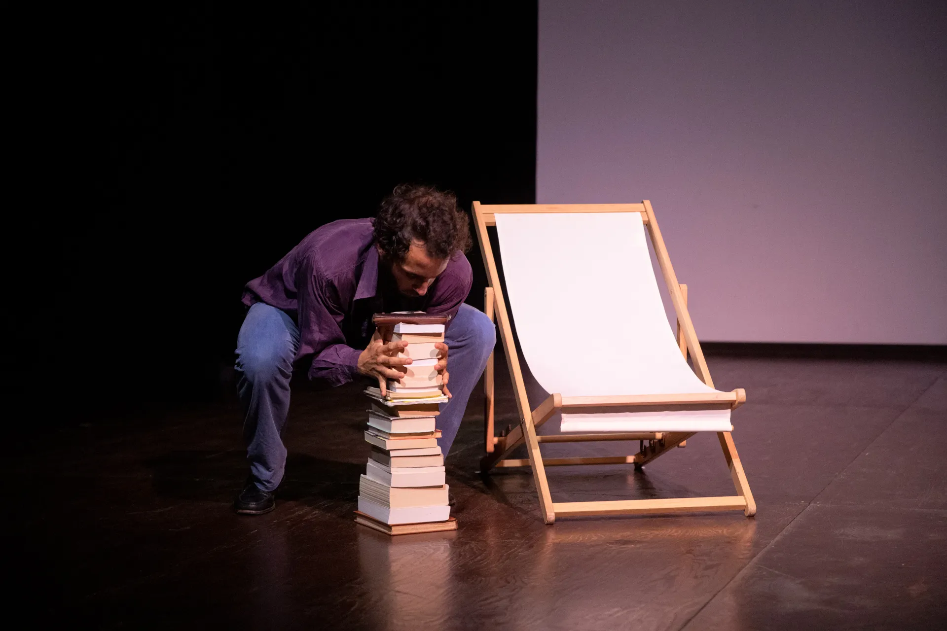 Performance teatrale al Festival di Spoleto con uomo e pila di libri