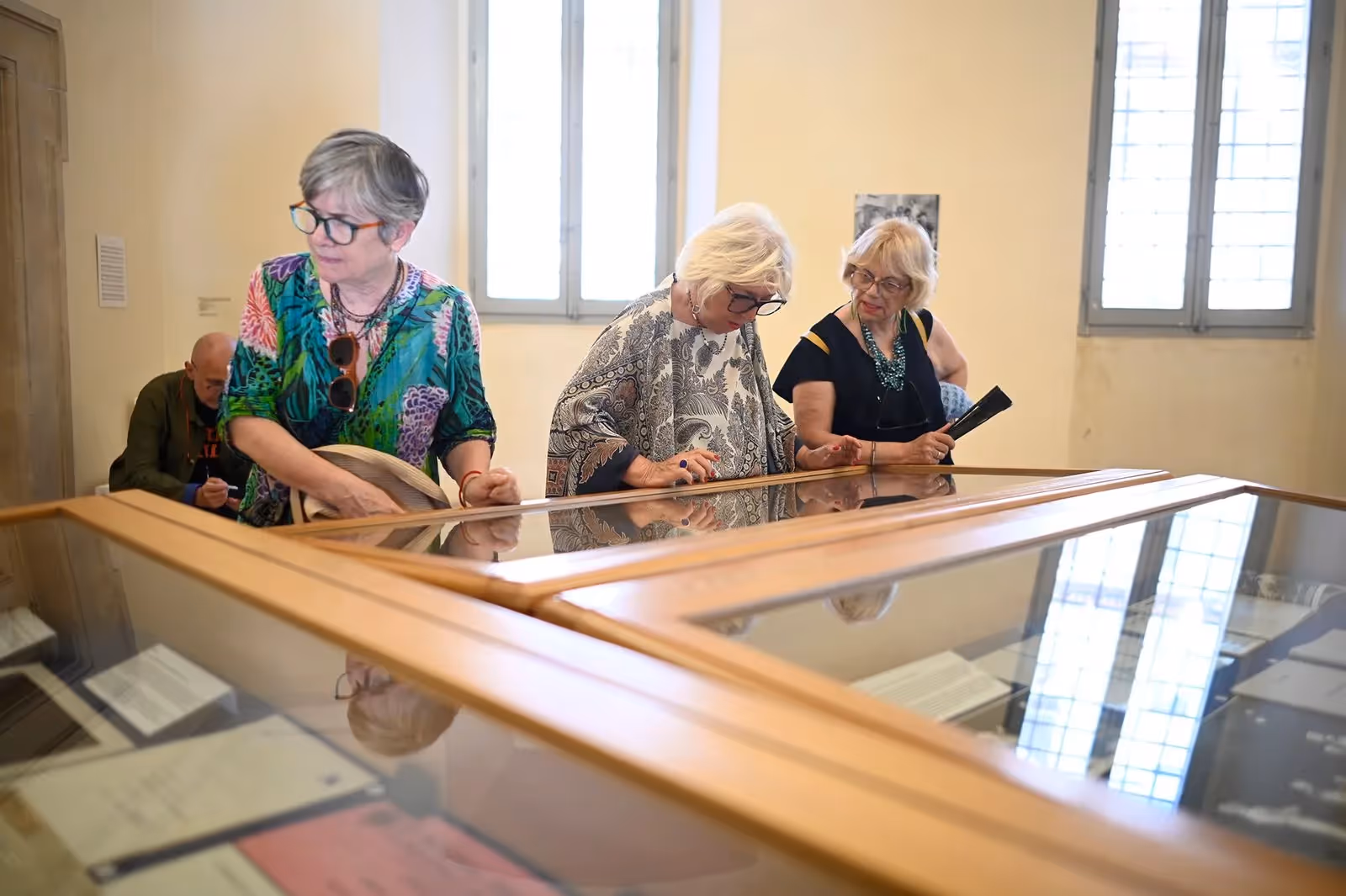 Tre donne al Festival di Spoleto esaminano documenti in una mostra storica