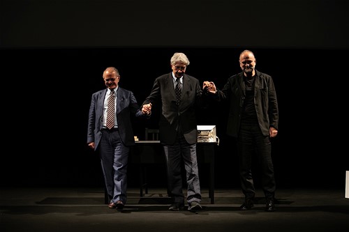 Tre uomini sul palco al Festival di Spoleto, in abiti formali scuri