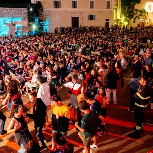 Folla gremita al Festival di Spoleto, pubblico affascinato sotto le luci notturne