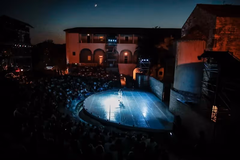 Spettacolo notturno al Festival di Spoleto, palcoscenico illuminato sotto la luna