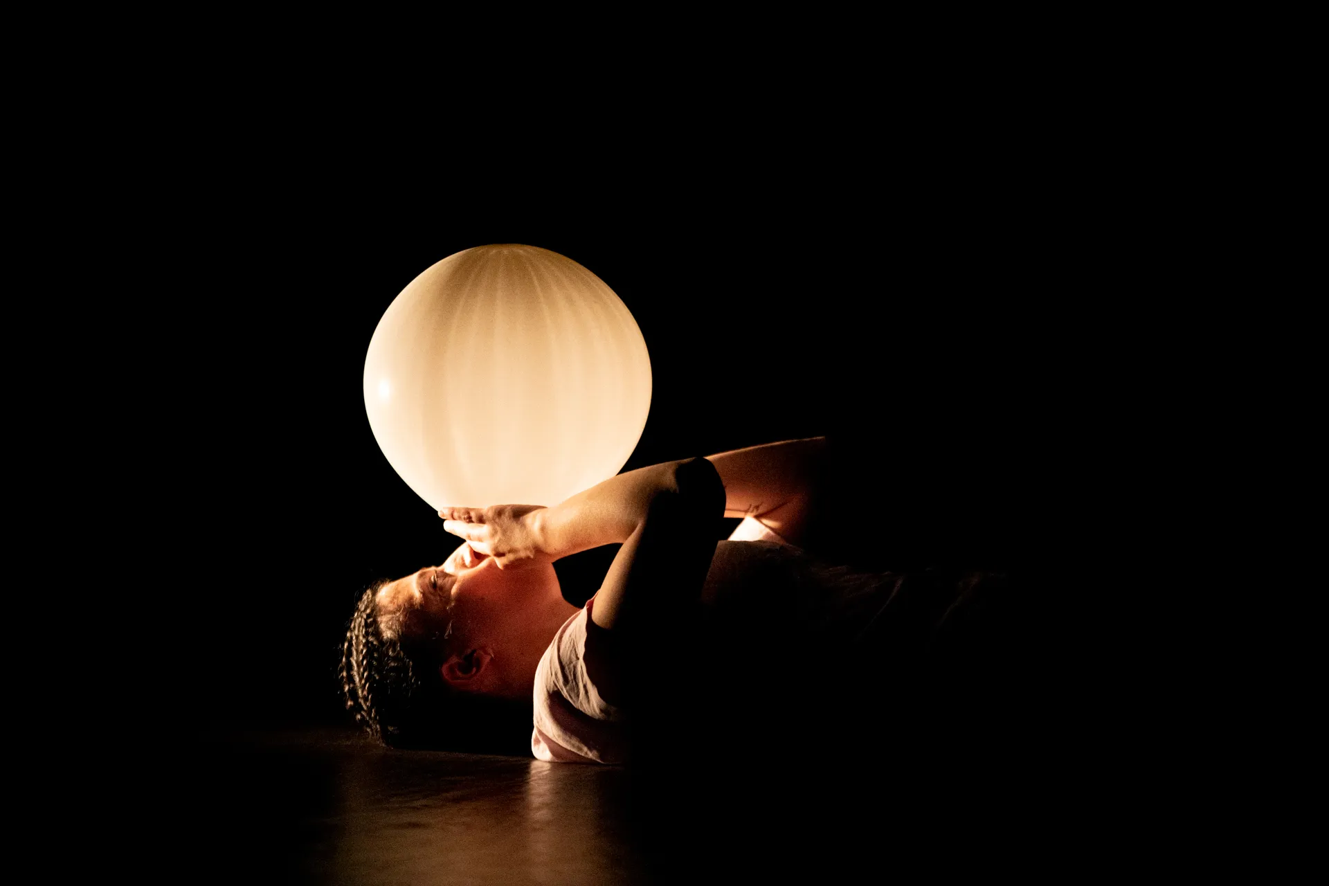 Performance artistica al Festival di Spoleto con sfera luminosa e movimento