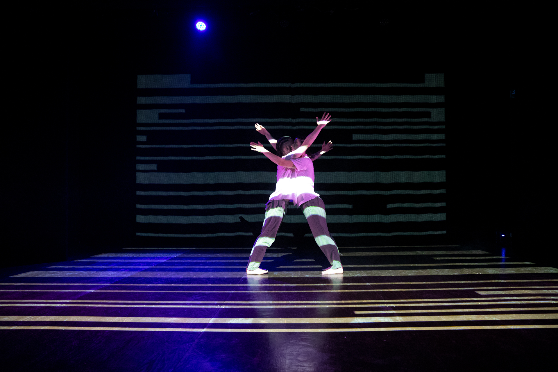 Performer sulla scena al Festival di Spoleto, illuminato da luce blu intensa