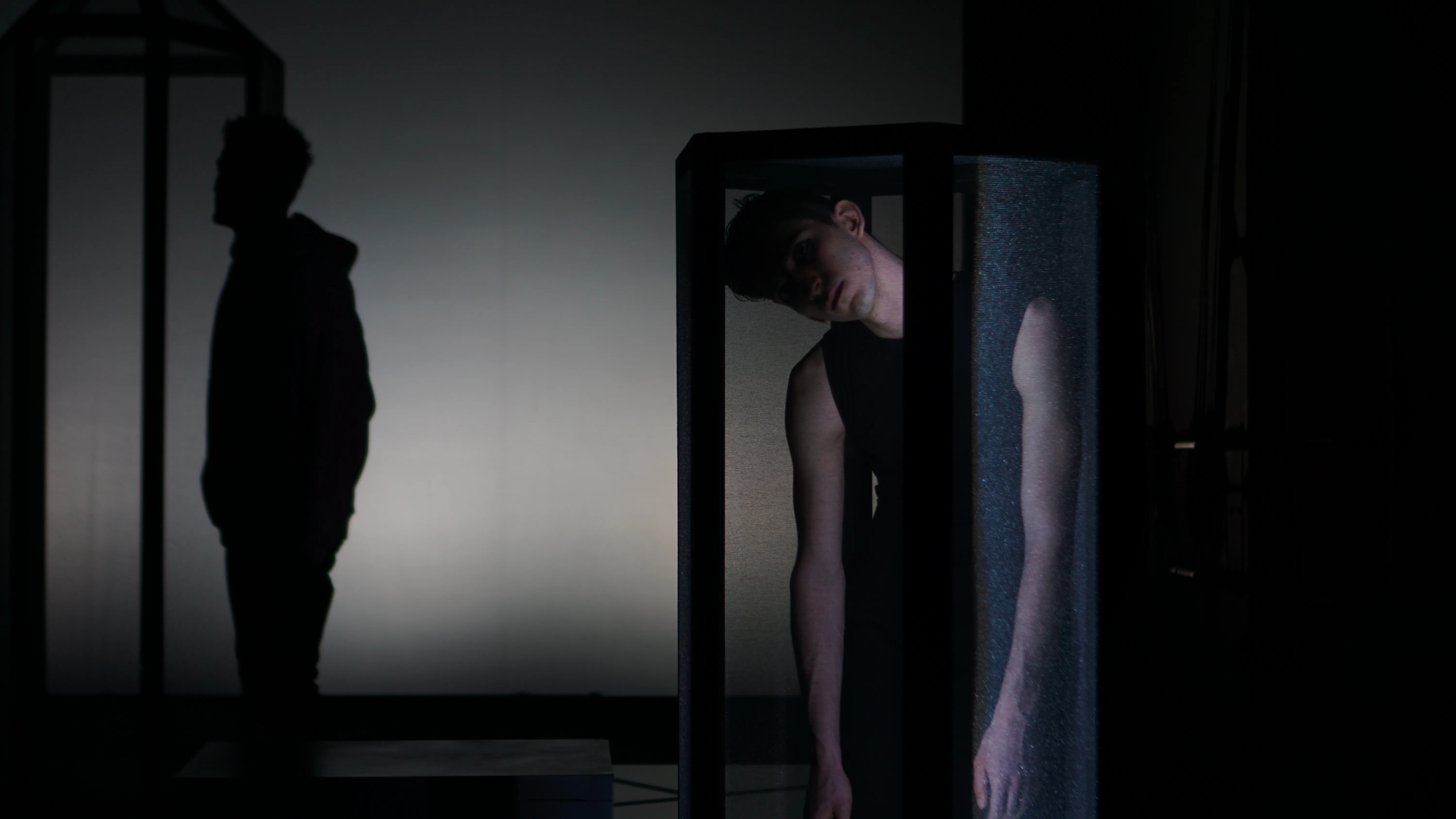 Performance artistica al Festival di Spoleto con figure oscure e riflessi