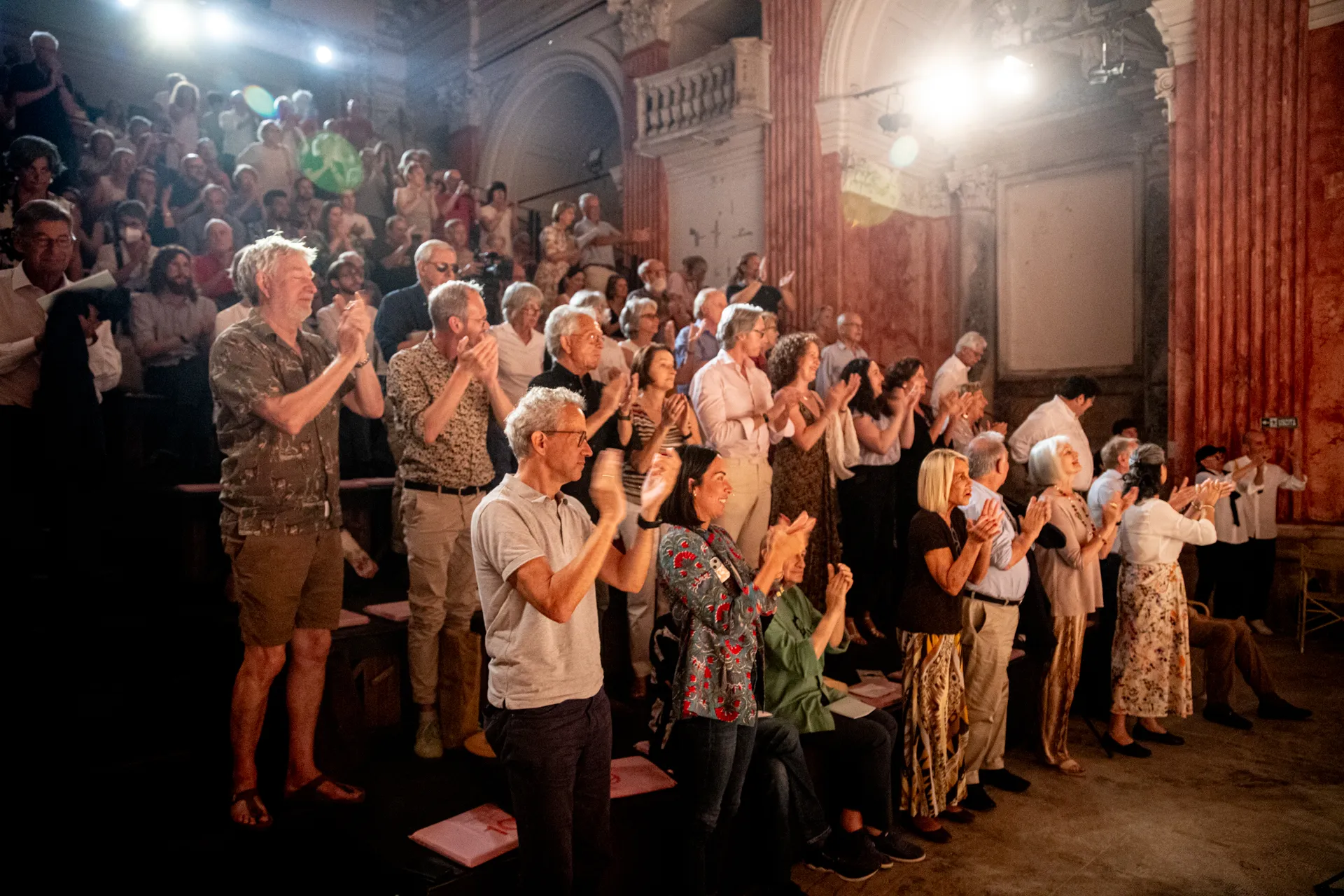 Pubblico emozionato applaude durante il Festival di Spoleto in un'antica sala