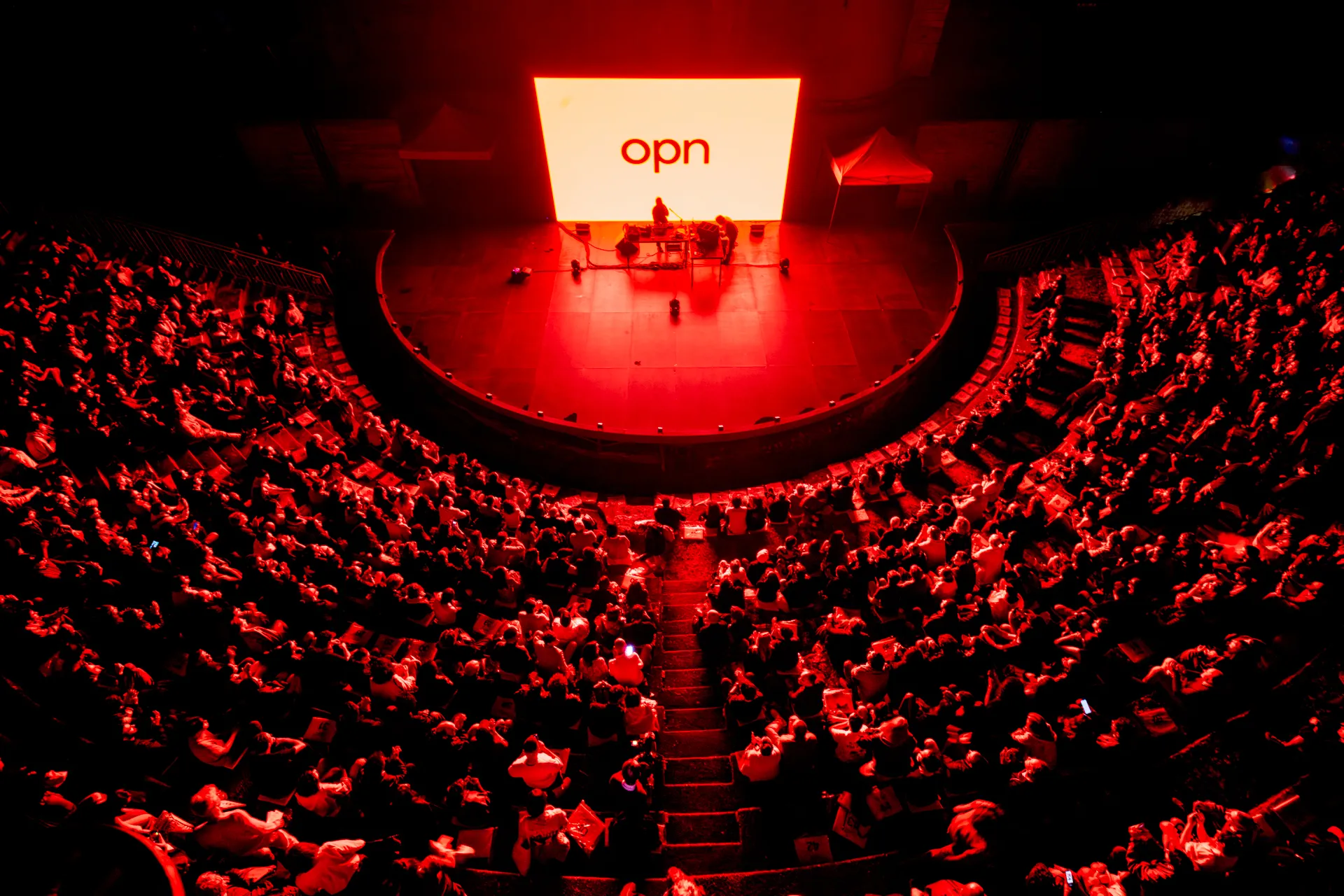 Festival di Spoleto performance with packed red-lit auditorium and OPN stage