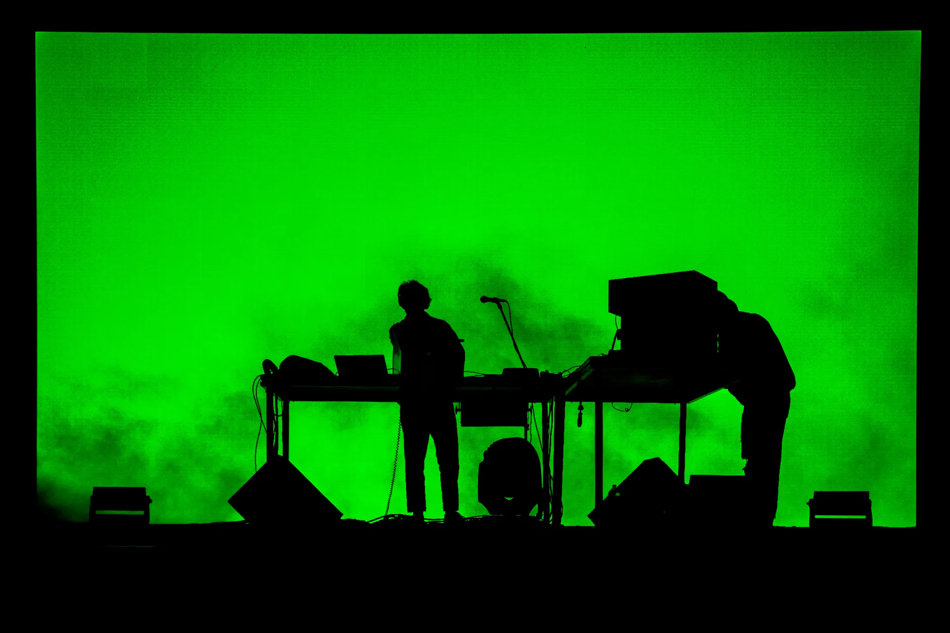 Electronic musicians performing at Festival di Spoleto against vibrant green backdrop