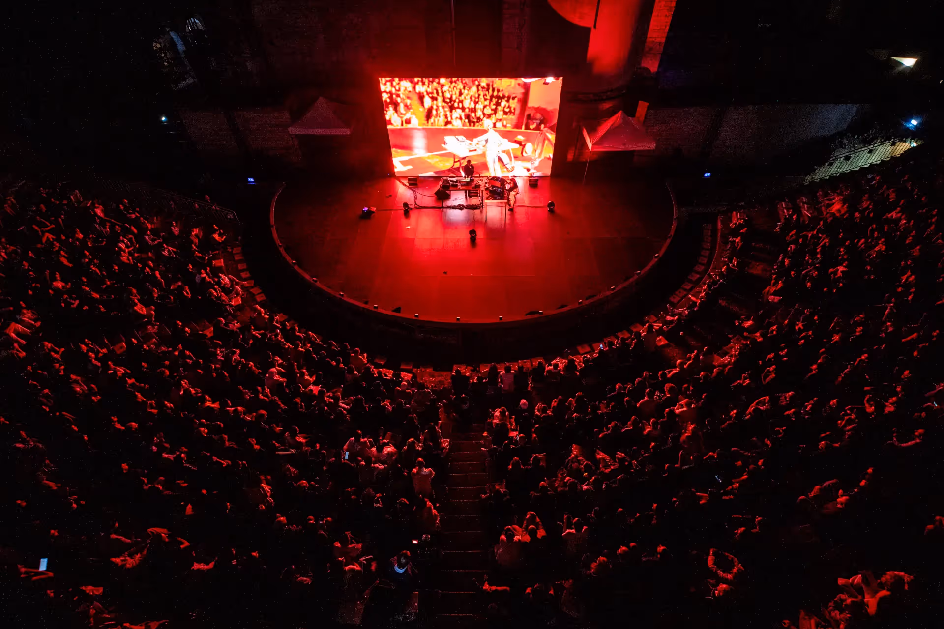 Palcoscenico rosso affollato durante il Festival di Spoleto con performance artistica