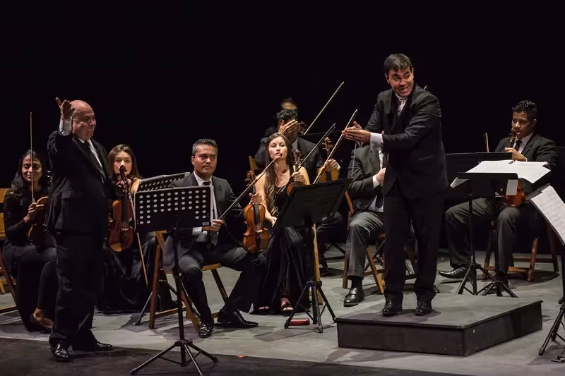 Orchestra performing at Festival di Spoleto, conductor leading musicians on stage