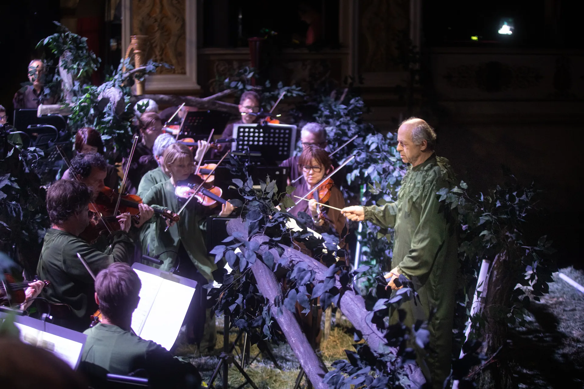 Orchestra performing amid foliage at Festival di Spoleto, conductor leading