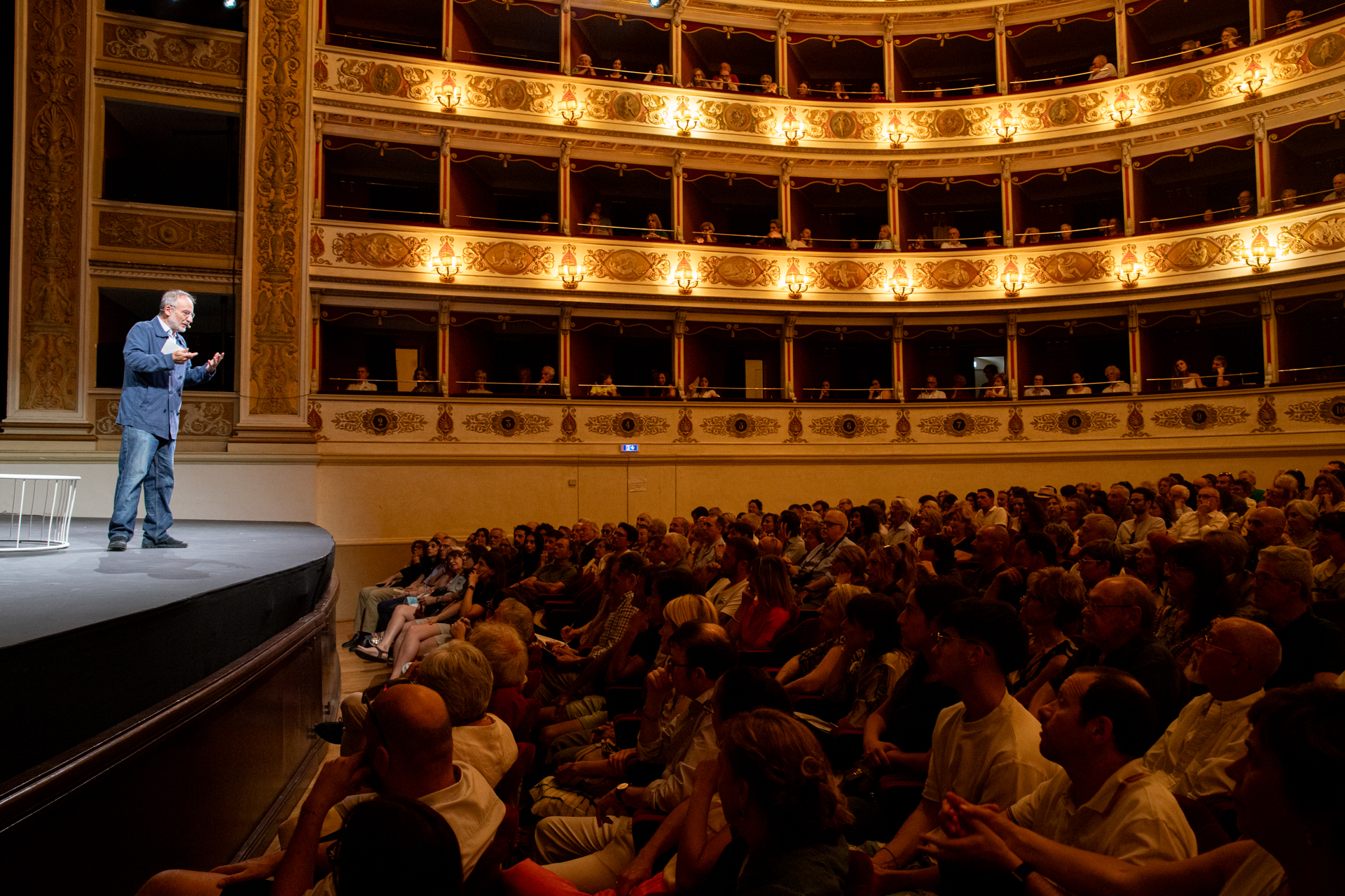 Festival di Spoleto speaker on stage at historic theater with packed audience