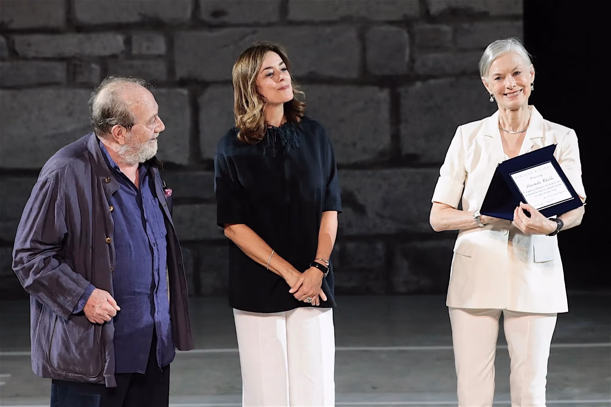 Festival di Spoleto award ceremony with three people on stone background