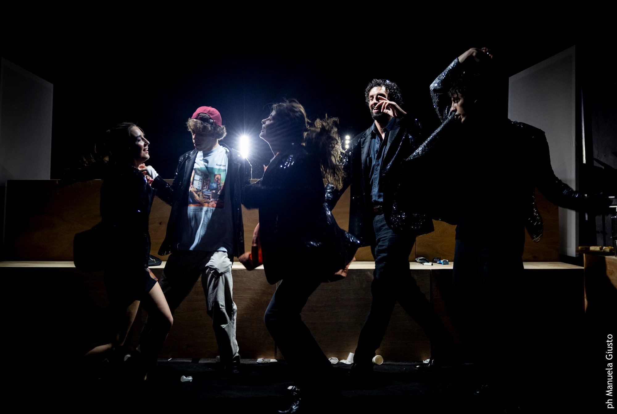 Artisti dinamici sul palco durante il Festival di Spoleto, illuminati drammaticamente