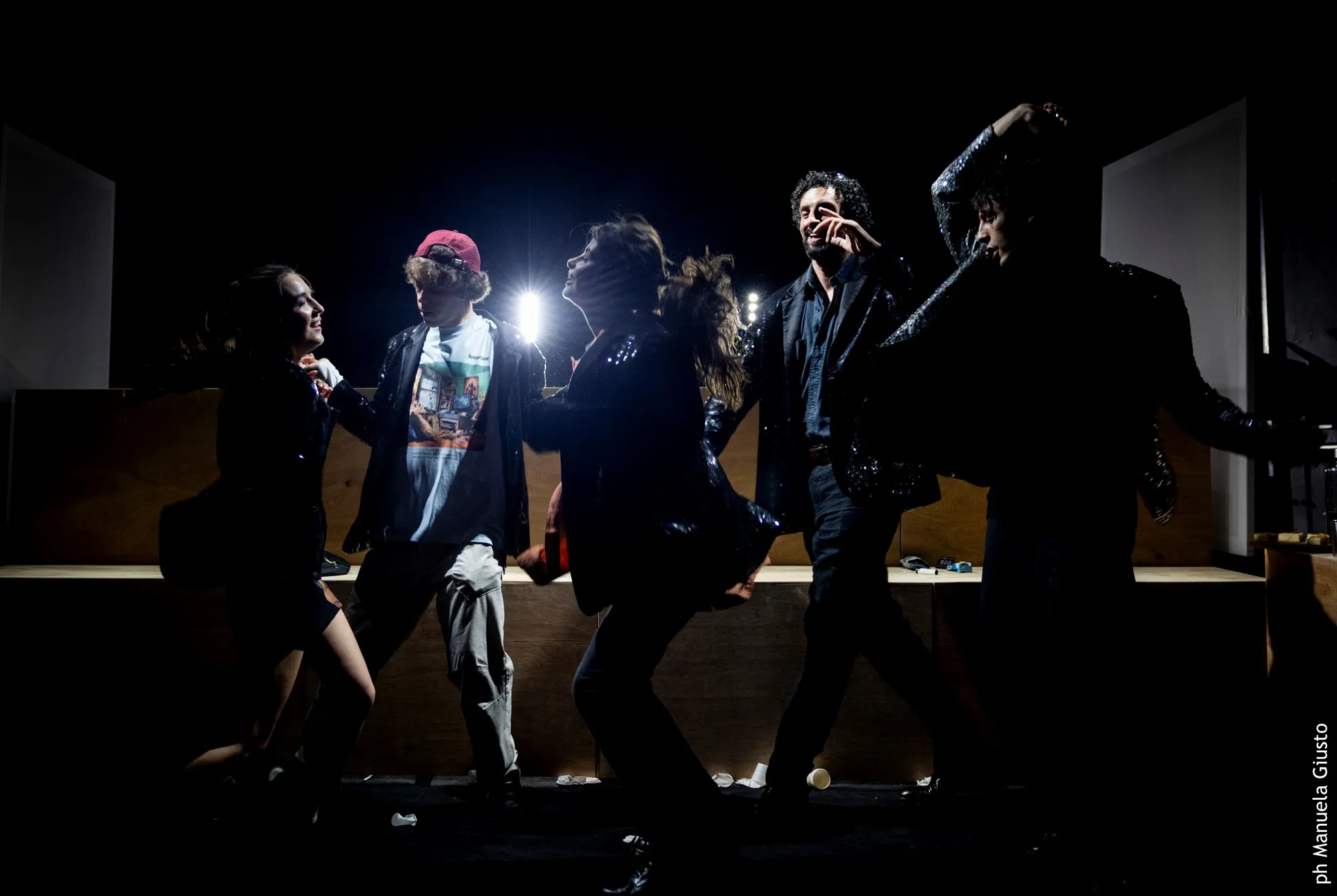 Artisti dinamici sul palco durante il Festival di Spoleto, illuminati drammaticamente