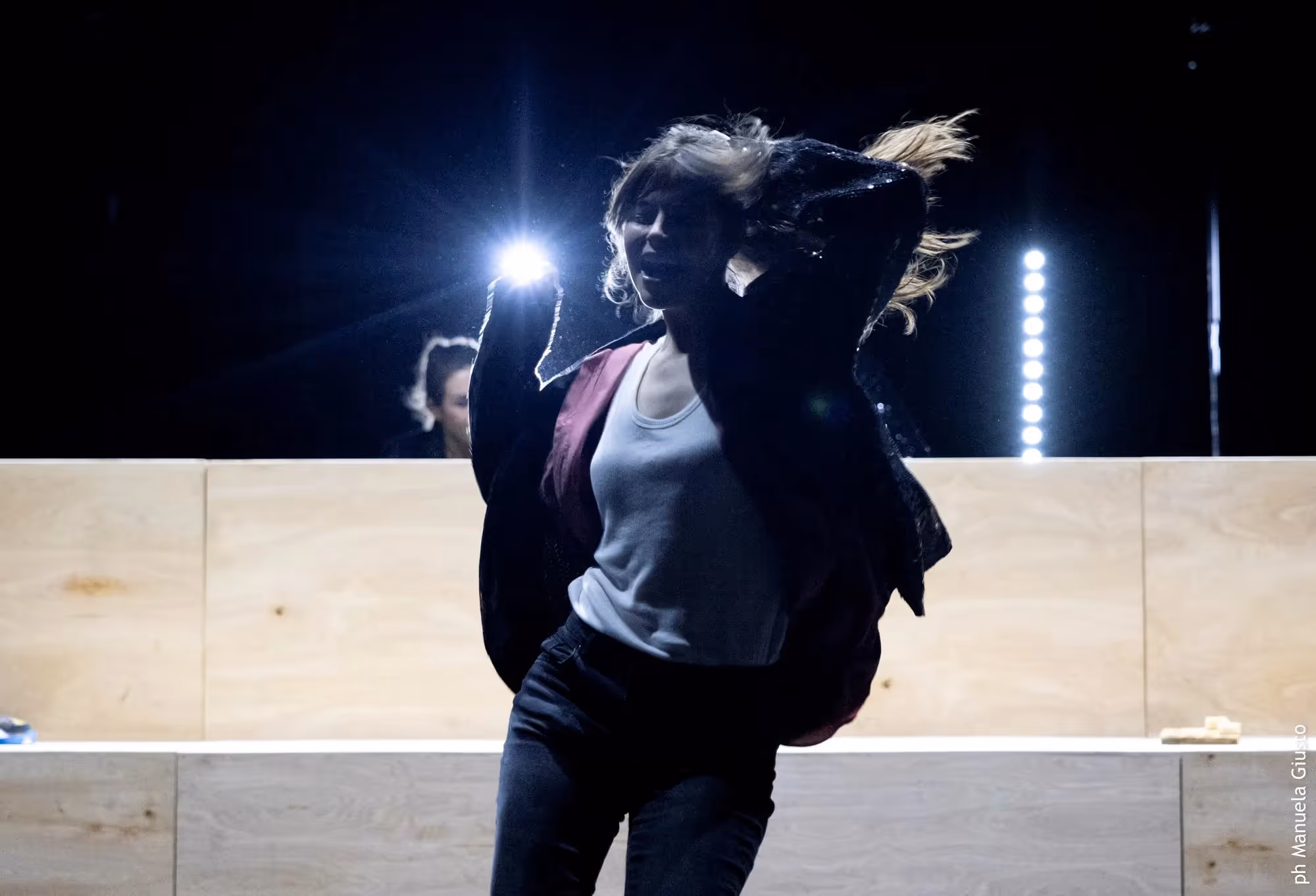 Performer dinamica al Festival di Spoleto, illuminata da luci teatrali intense