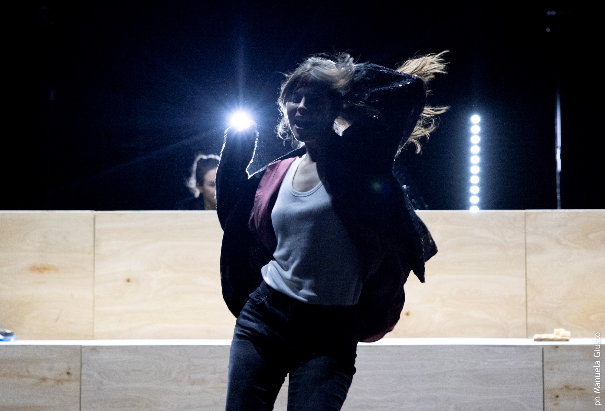 Performer dinamica al Festival di Spoleto, illuminata da luci teatrali intense