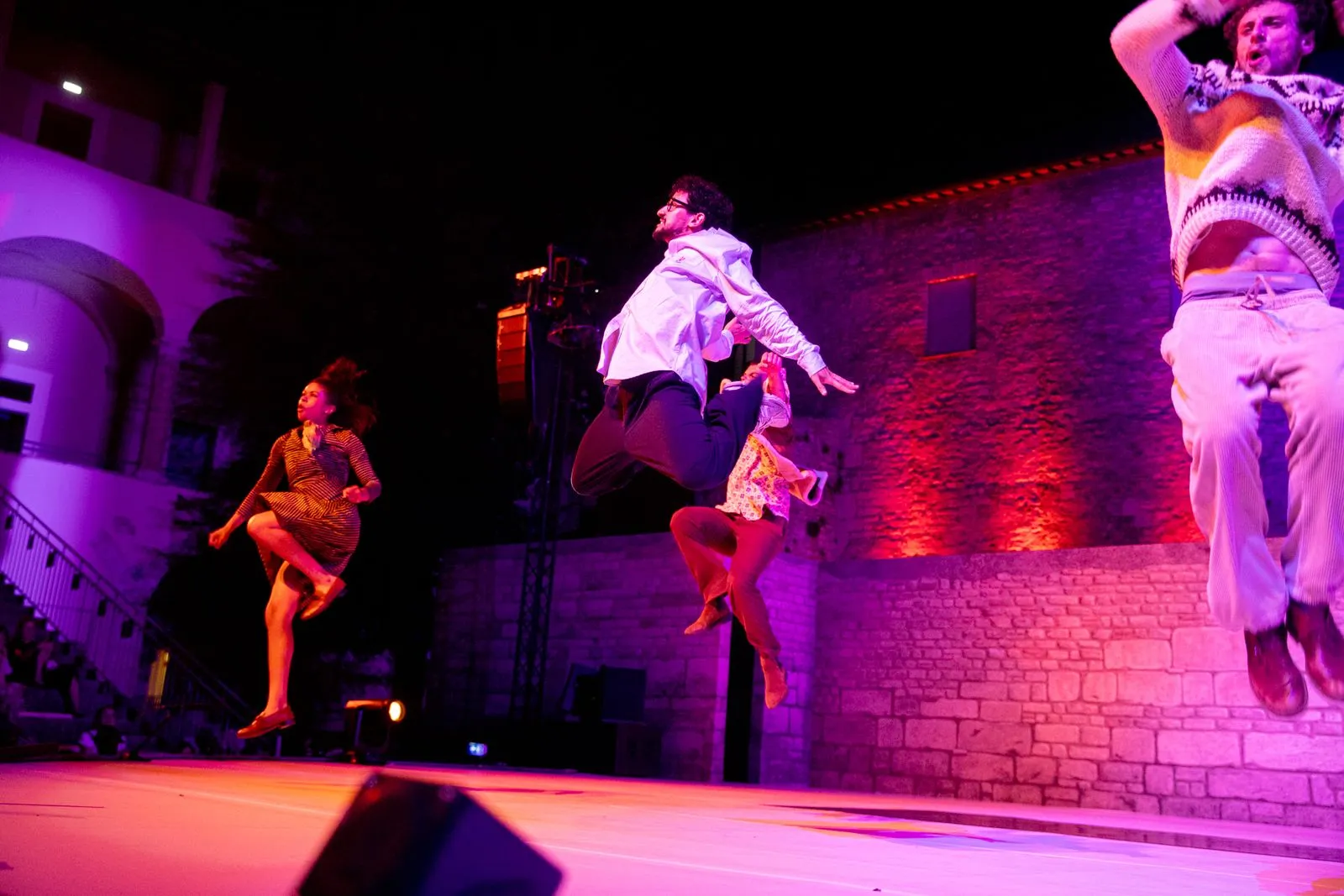 Danzatori dinamici durante il Festival di Spoleto, illuminati da luci viola