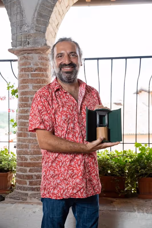 Festival di Spoleto attendee in red shirt holding book near brick archway