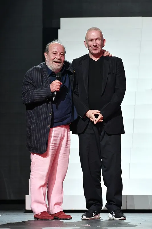 Two artists at Festival di Spoleto, sharing a moment on stage in contrasting outfits