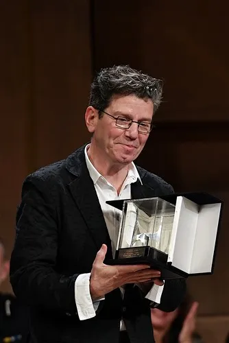 Premiazione al Festival di Spoleto: artista riceve riconoscimento con sorriso