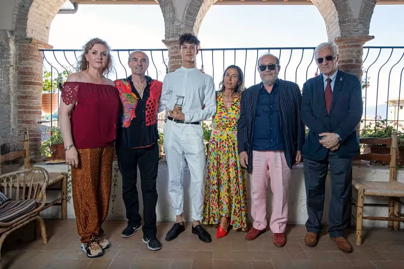 Diverse group posing at Festival di Spoleto artistic event in stone archway