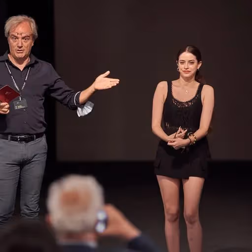 Momento teatrale al Festival di Spoleto con performer sul palcoscenico scuro