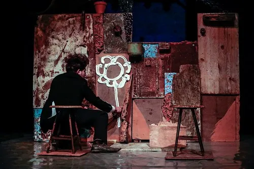 Scena suggestiva al Festival di Spoleto, artista seduto tra oggetti vintage