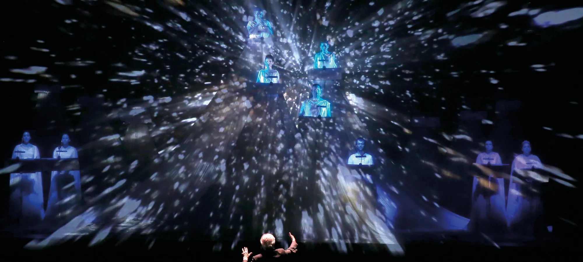 Festival di Spoleto performance with blue holographic figures and dynamic lighting