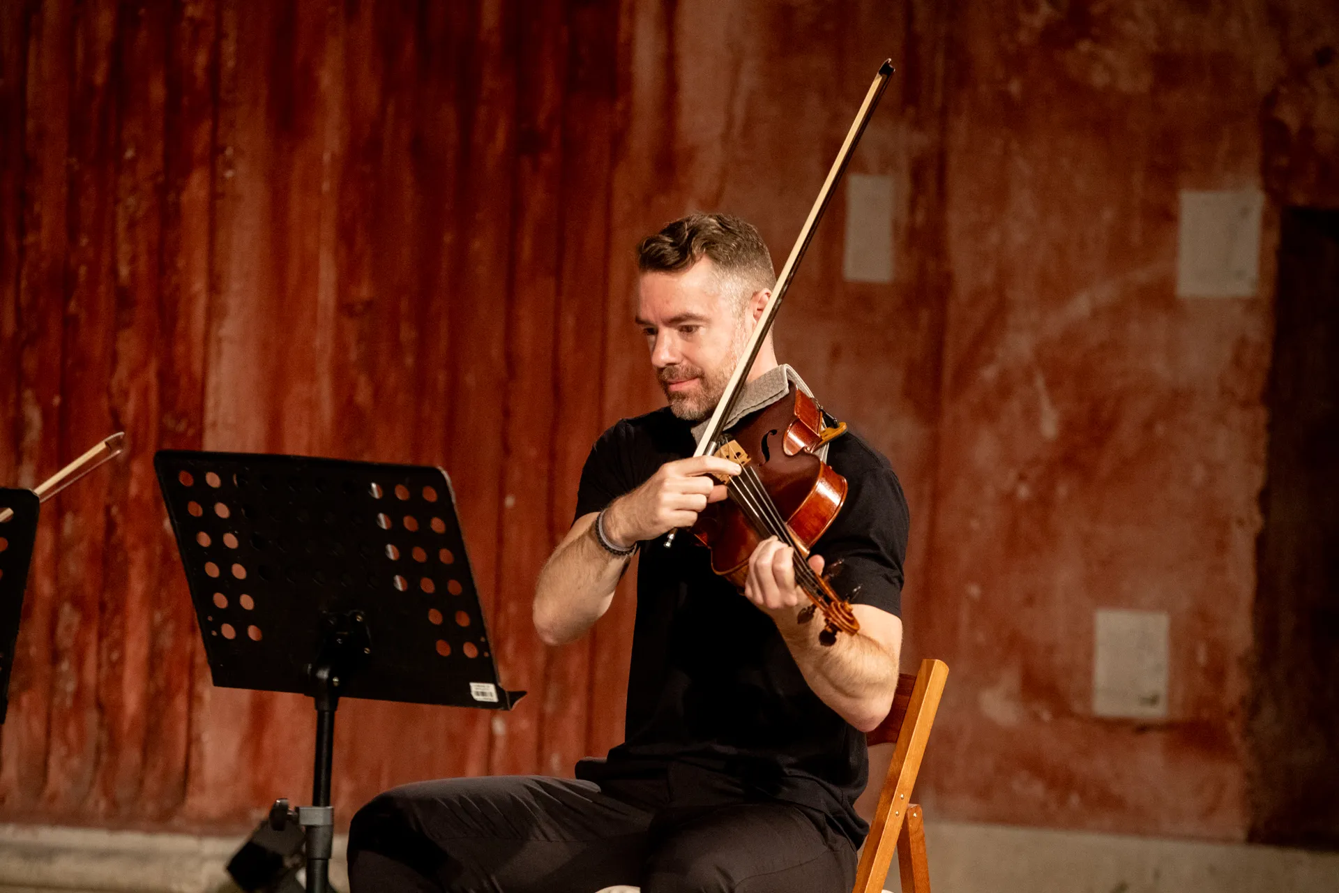 Violinist performs at Festival di Spoleto, seated with music stand