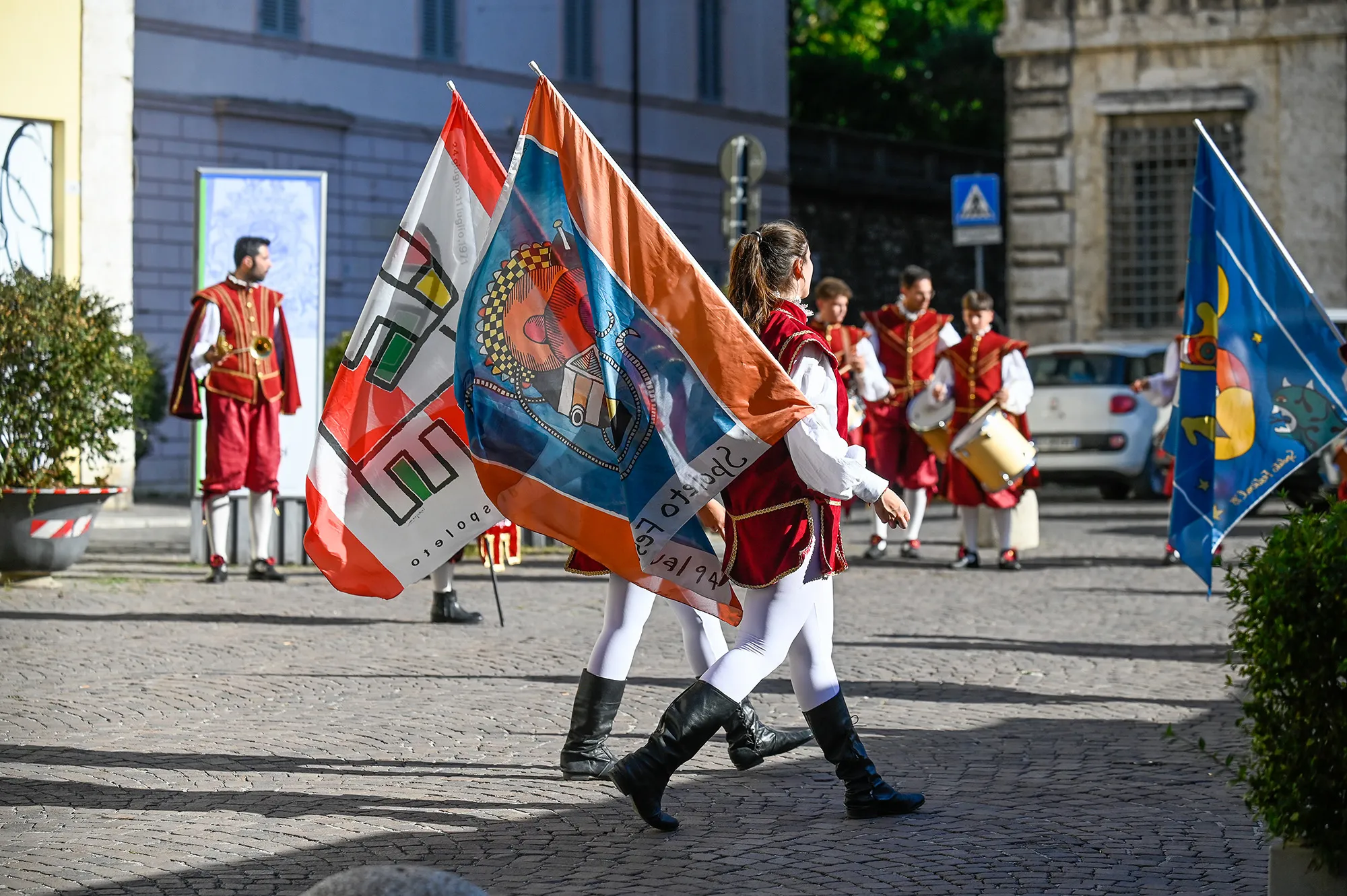 Festival di Spoleto performers parade with colorful flags in historic costumes