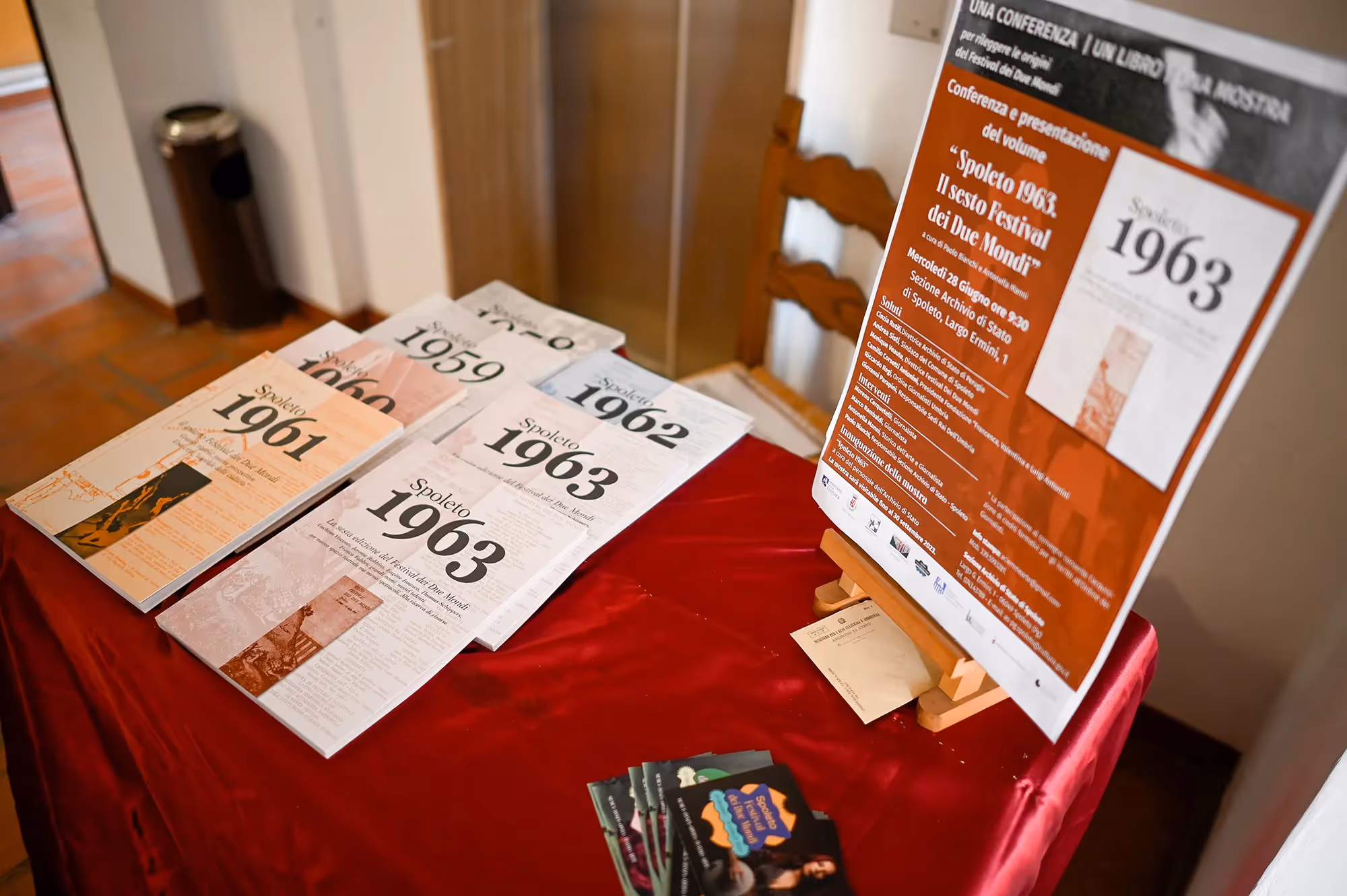 Festival di Spoleto 1963 publications and conference poster on red tablecloth