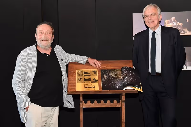 Festival di Spoleto exhibition display with two men and wooden presentation stand