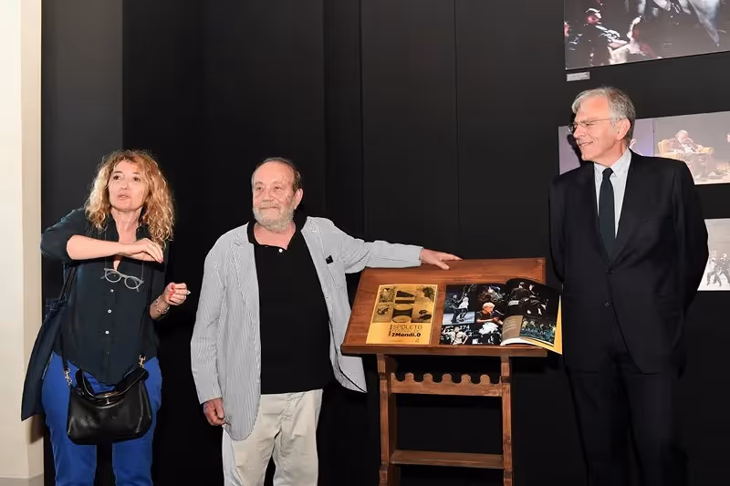 Artists at Festival di Spoleto exhibition, displaying photographs on wooden stand