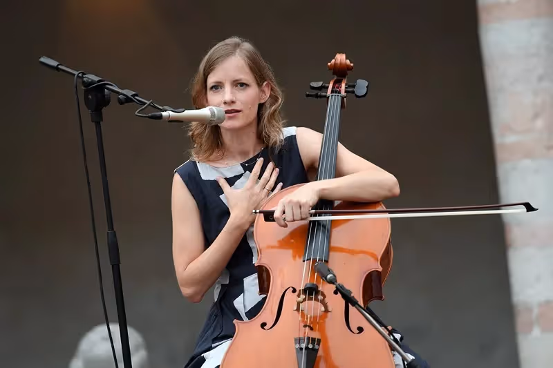 Cellist performing at Festival di Spoleto, singing passionately while playing