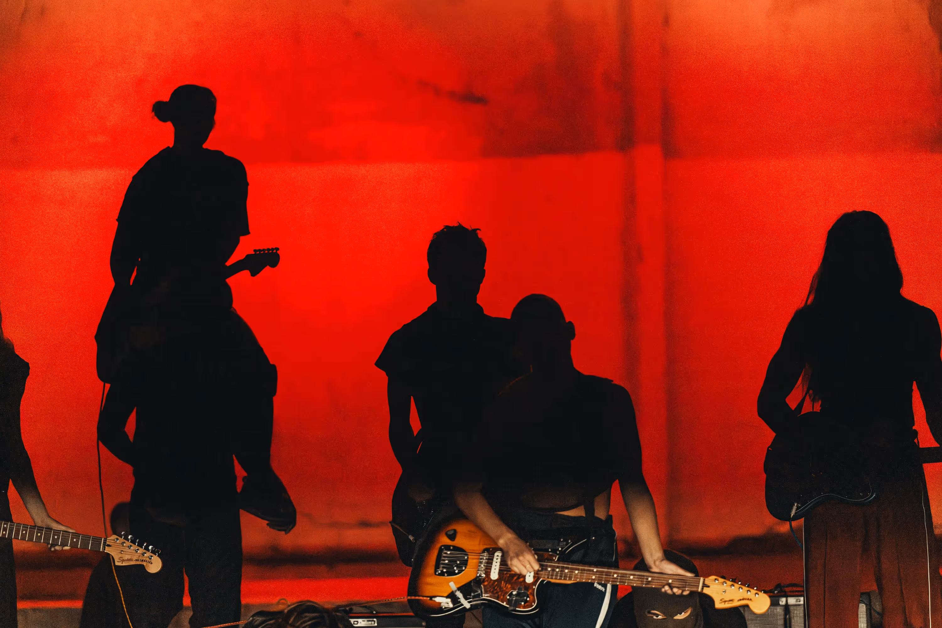 Silhouette di musicisti sul palco del Festival di Spoleto con sfondo rosso