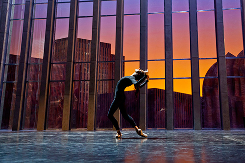 Dancer performs at sunset during Festival di Spoleto, silhouetted against vibrant sky