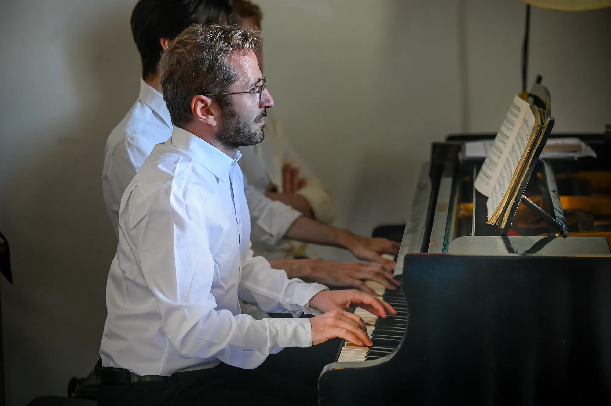 Pianista durante il Festival di Spoleto, suona concentrato in camicia bianca