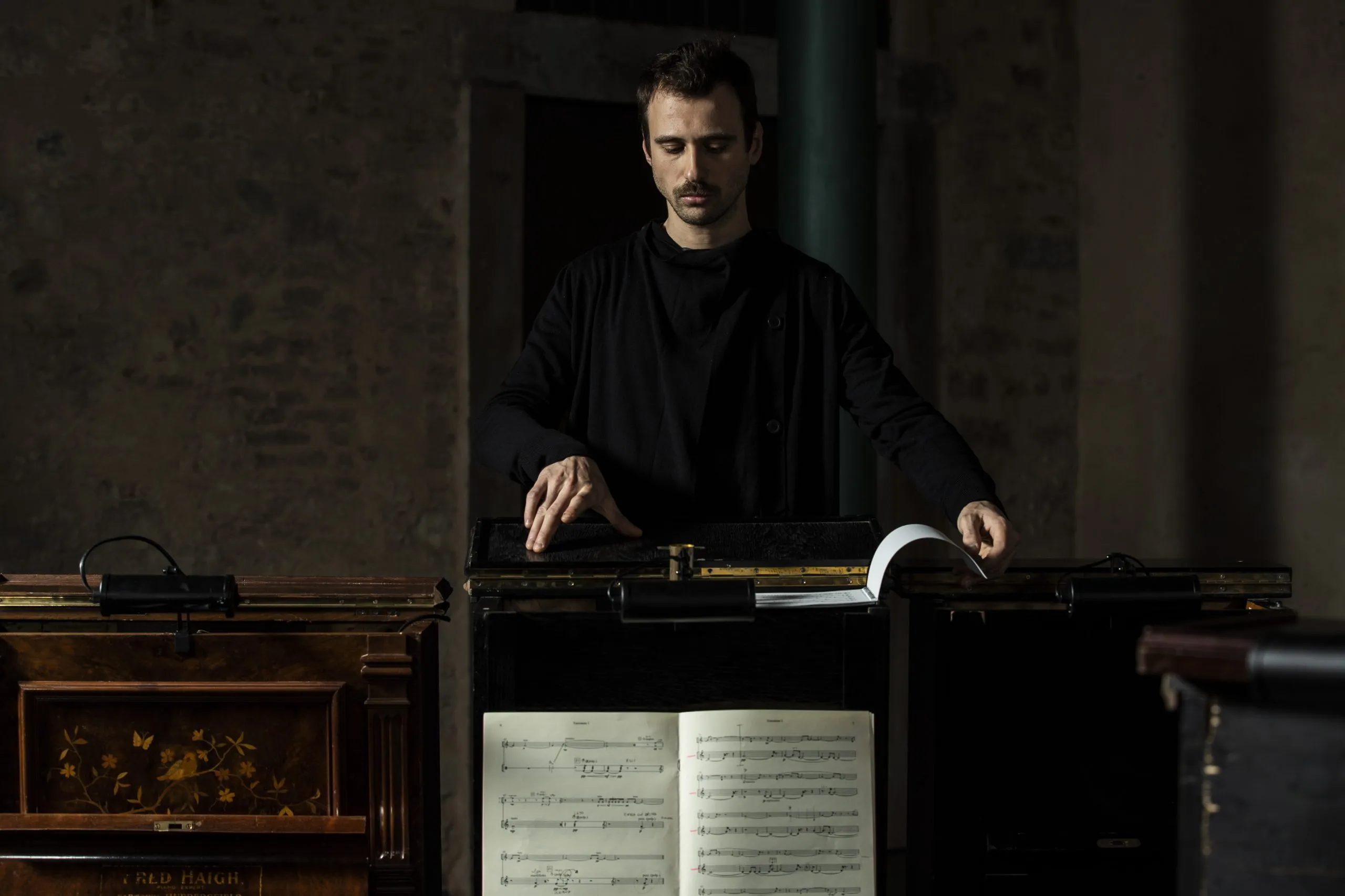 Musicista in nero al Festival di Spoleto con spartiti e strumento antico